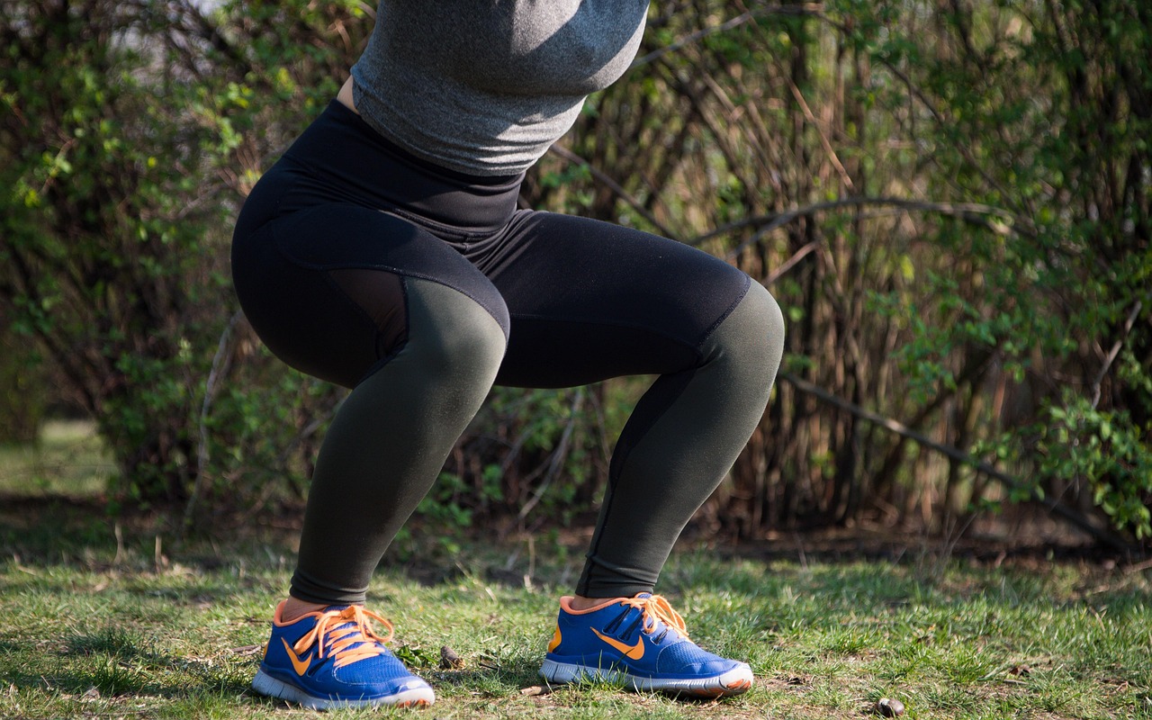 Person performing a body weight squat workout demonstrating proper form and depth